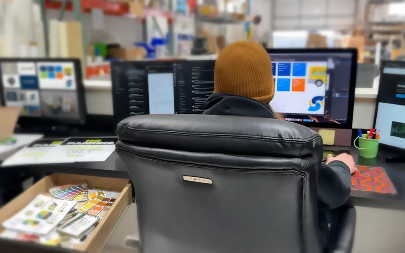CL Visual designer at the workstation, prepping a print-ready file
