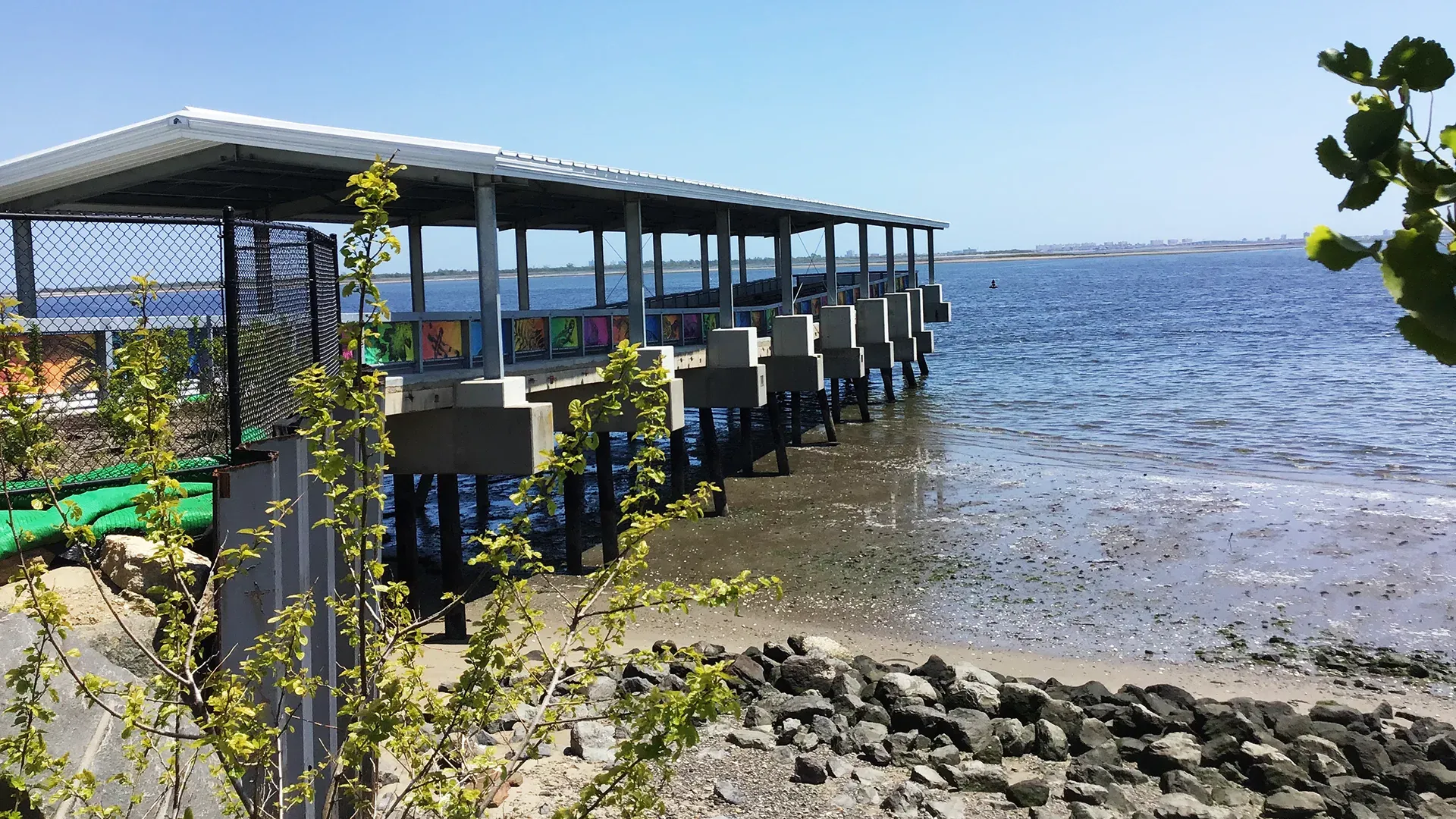 Mesh fence banners installed along the pier fencing at Shirley Chisholm State Park